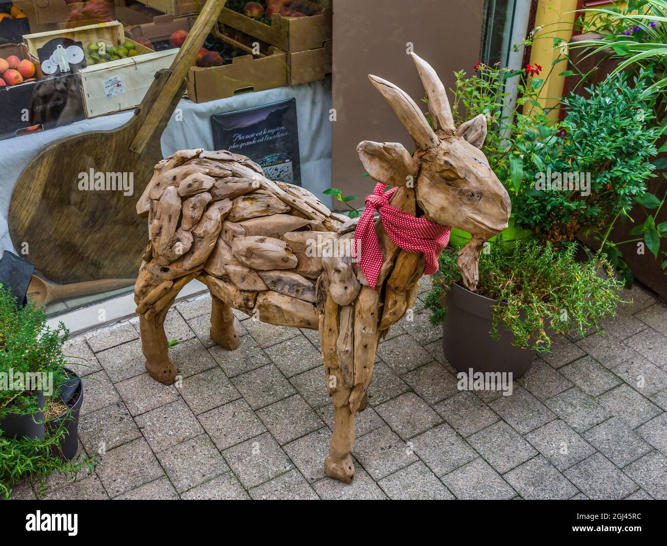 Modelo a tamaño natural de cabra de madera fuera de la tienda de alimentos en Saint-Léonard-de-Noblat, Haute-Vienne (87), Francia. Foto de stock