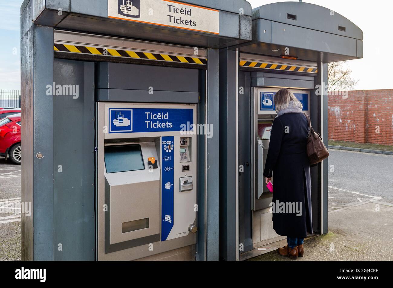 Woman compra un billete de tren en una máquina de billetes en Midleton Railway Station, East Cork, Irlanda. Foto de stock