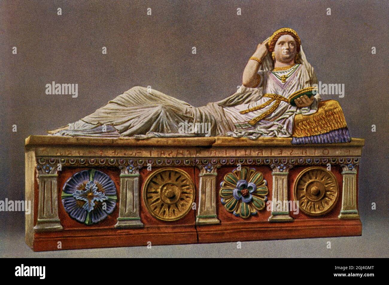 En esta ilustración de 1910 se muestra un sarcófago etrusco de Chiusi. El original se encuentra en el Museo Arqueológico de Florencia. La portada de este sarcófago de terracota representa a Larthia Seianti, una dama rica que vivió en el sur de la Toscana cerca de Chiusi en el segundo siglo antes de Cristo. La mujer es retratada acostada en un kline. Ella está usando una ropa suntuosa y colorida, y su figura está adornada con ricas joyas. Un diadema hecho por flores, presumiblemente una corona, embellece su cabello. Un collar decorado con un medallón que representa la cabeza de Medusa, cuelga alrededor de su cuello. El civil etrusco Foto de stock