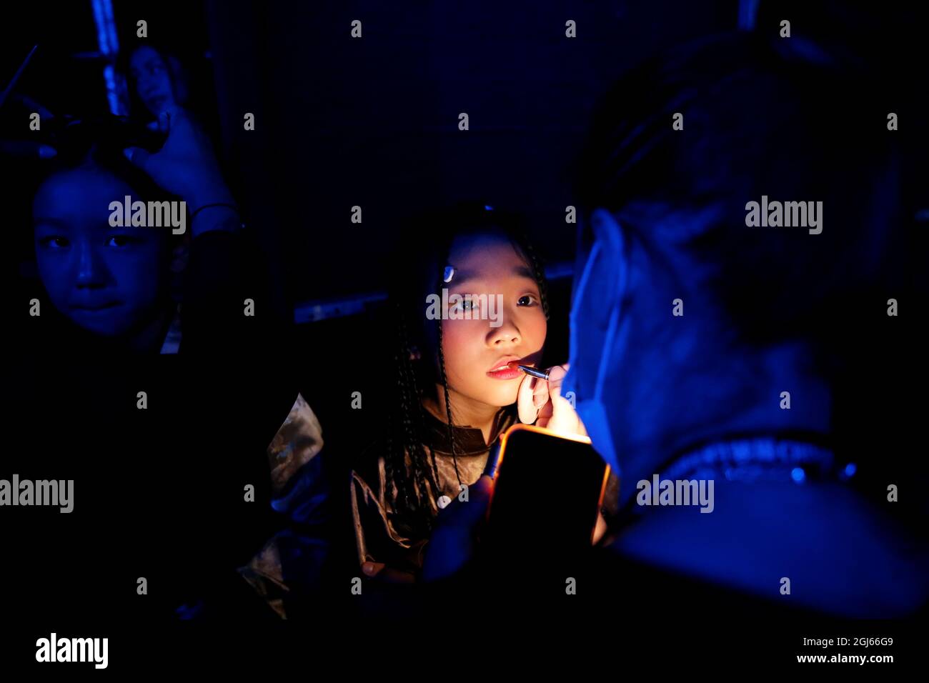 Un modelo infantil tiene su maquillaje hecho antes de la AJ-NAMO primavera  / verano 2022 colección de muestra por el diseñador tibetano Zewang Namo,  durante China Fashion Week en Beijing, China, 9