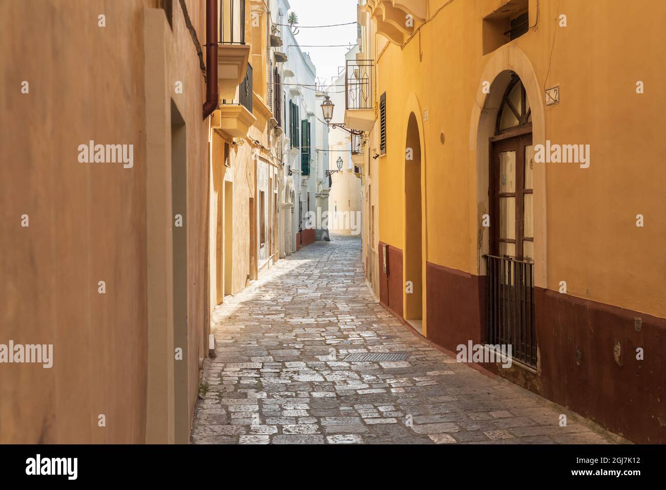 Italia, Apulia, Provincia de Lecce, Gallipoli. Estrecha calle de adoquines. Foto de stock