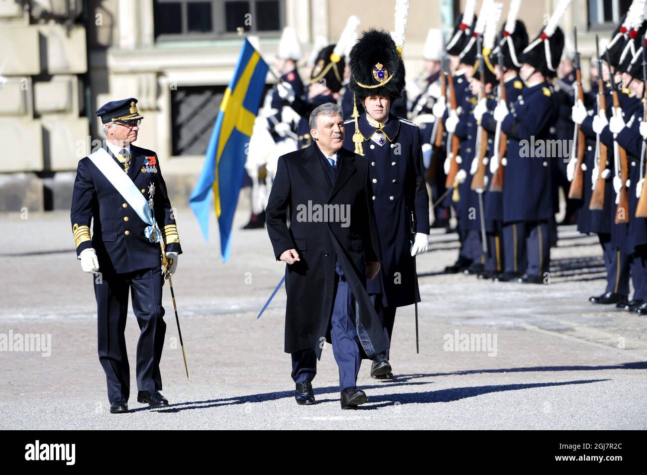 La esposa del presidente turco Abdullah Gul es vista junto con el rey Carl Gustaf de Suecia durante la inspección de la Guardia Real durante una ceremonia en el patio del Palacio Real en Estocolmo, Suecia, el 11 de marzo de 2013. El Presidente turco realiza una visita de Estado a Suecia de tres días de duración. Foto de stock