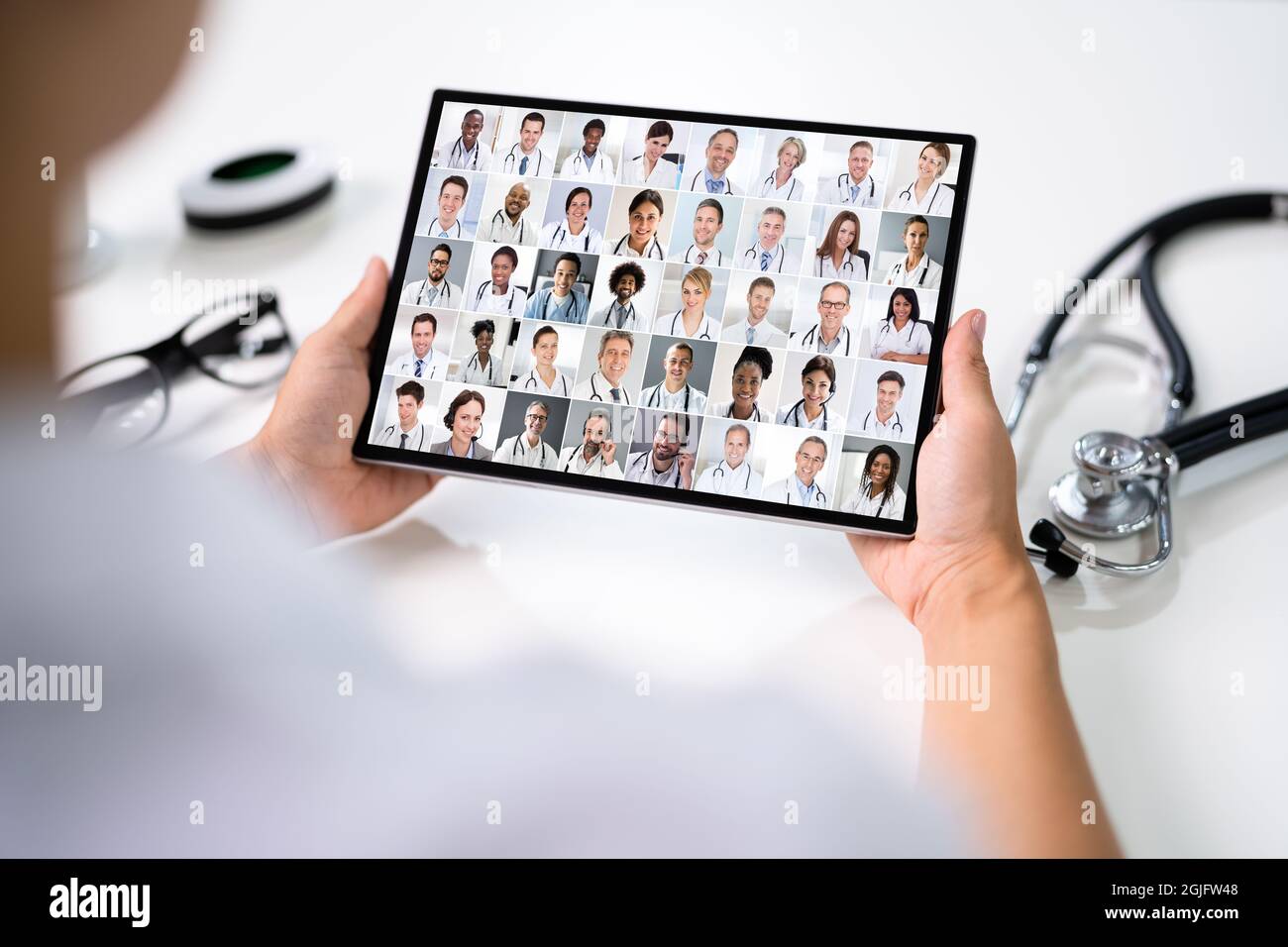 Doctor en Video Conferencia médica en línea con Equipo diverso de Trabajadores hospitalarios Foto de stock