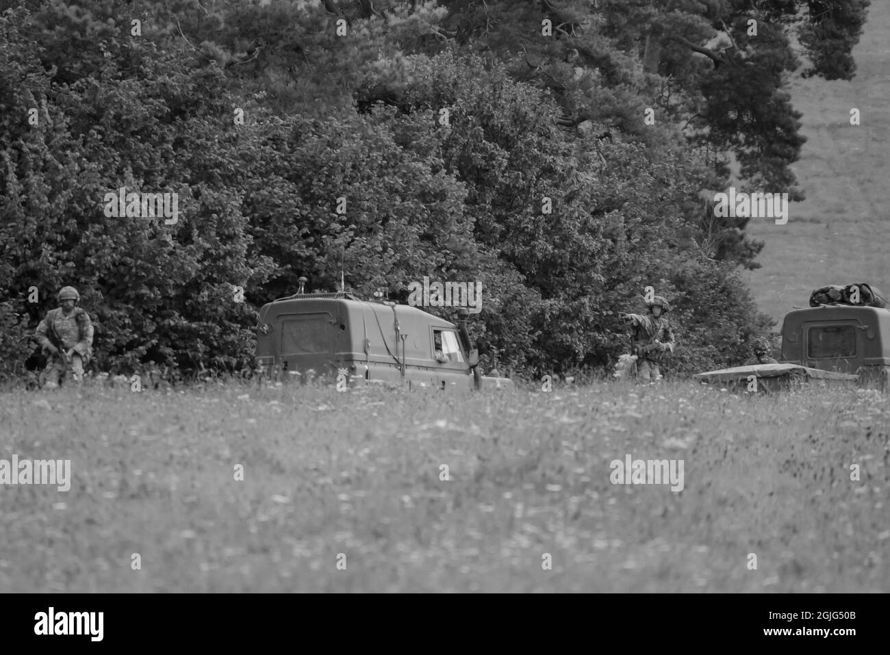 El ejército británico Land Rover Wolf 4 x 4 militar de vehículos utilitarios ligeros con soldados de pie desplegados en el ejercicio, Salisbury Plain Reino Unido Foto de stock