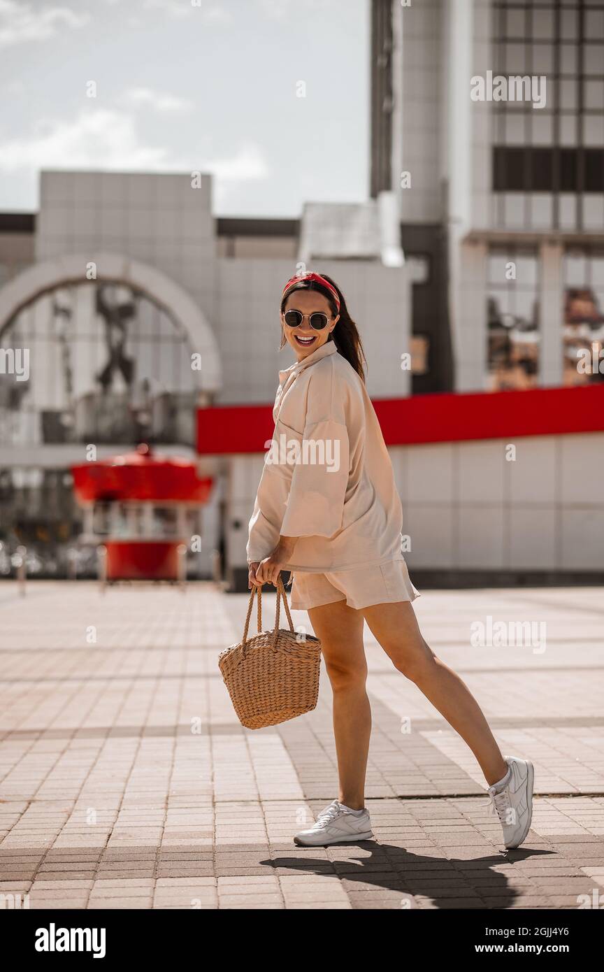 Una joven mujer bonita con ropa de color beige en la calle que parece feliz  Fotografía de stock - Alamy