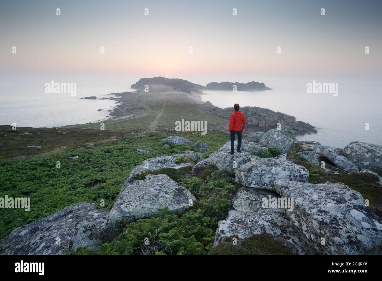 Hombre viendo la puesta de sol en Shipman Head. Bryher, Islas de Scilly. Cornwall, Reino Unido. Foto de stock