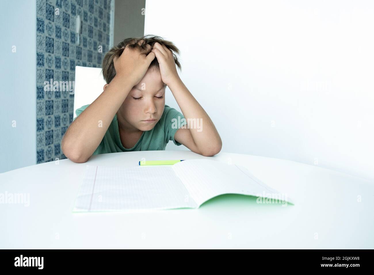Niño triste con libro hace la tarea de la escuela. Regreso a la escuela. Niño infeliz con libros de texto. Distancia learnin Foto de stock