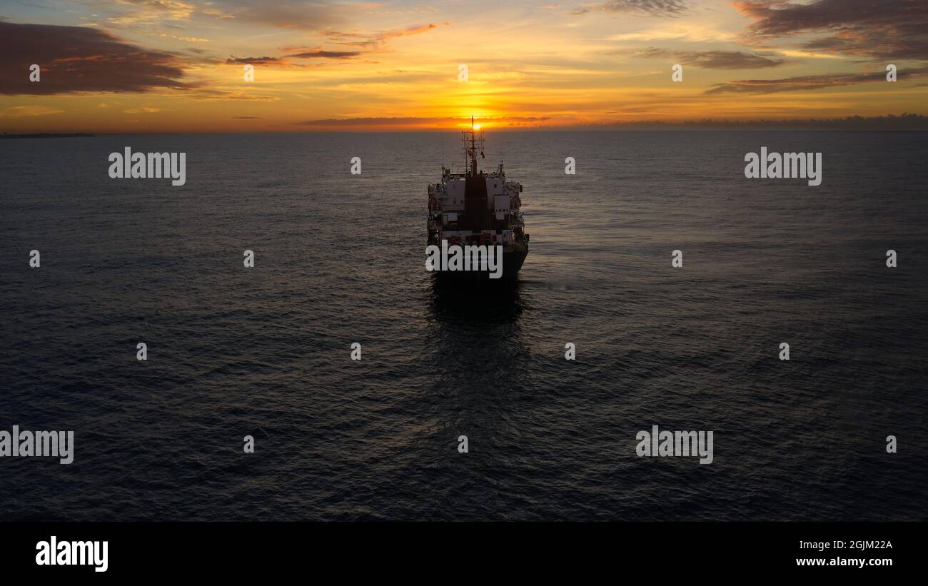 Hermoso amanecer sobre las aguas del Mar Caribe, entre el agua y el cielo, el barco era nuestro modelo. Drone tiro que revela el horizonte Foto de stock