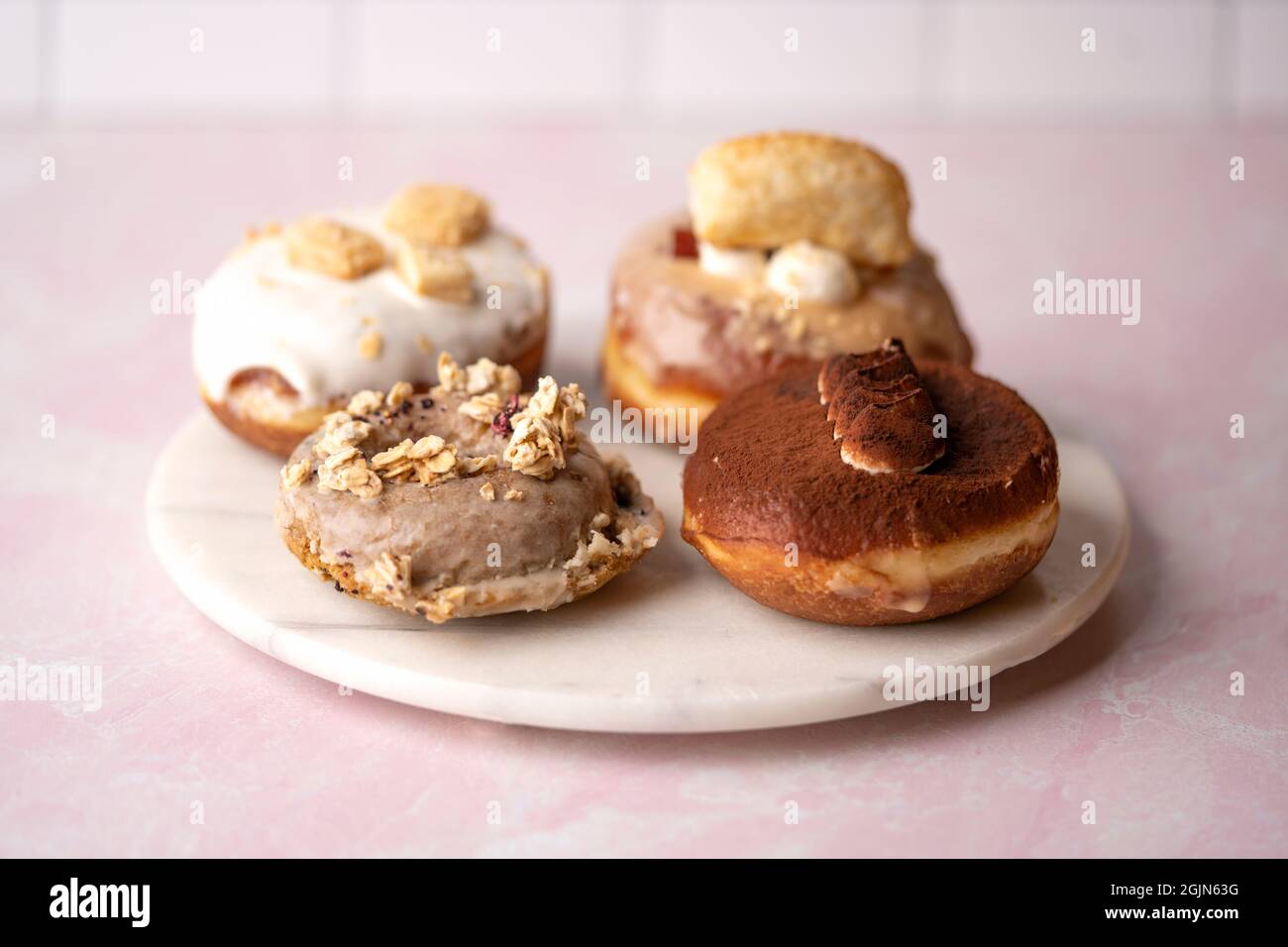 Varios tipos de donuts en un plato de mármol, comida Foto de stock