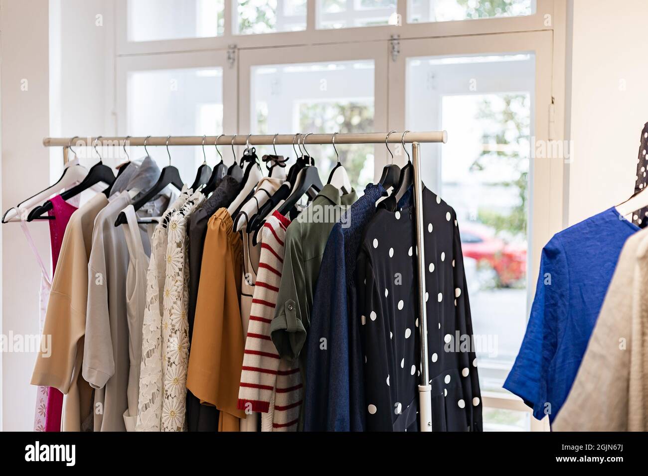 Ropa moderna y con estilo para mujer en una percha. Ropa de marca en una  sala de espectáculos. Fondo claro. Tienda de moda, sala de espectáculos,  tiendas o de temporada Fotografía de
