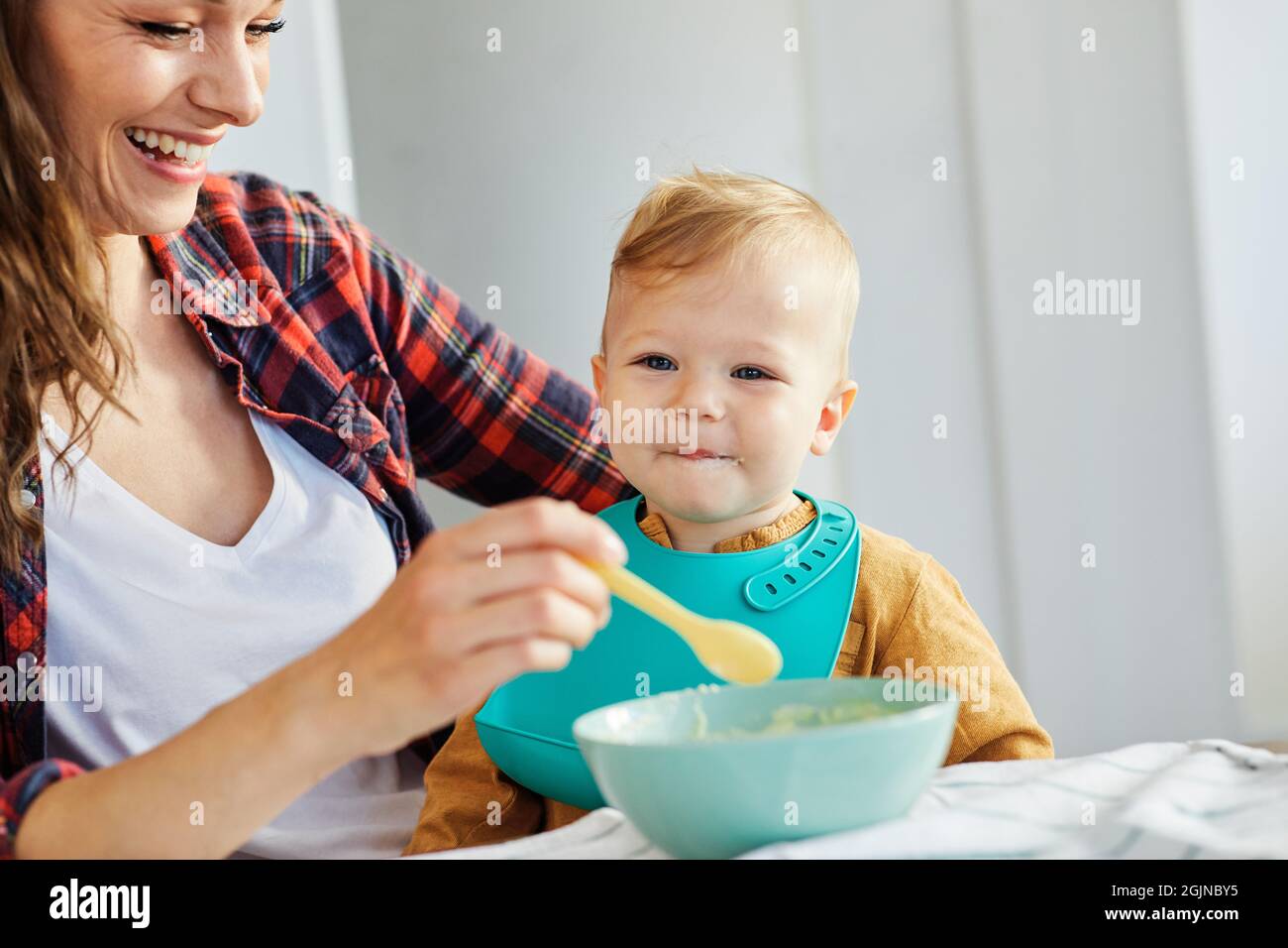alimentación de la madre comida del bebé niño comiendo cuidado de la familia infancia cuchara linda Foto de stock