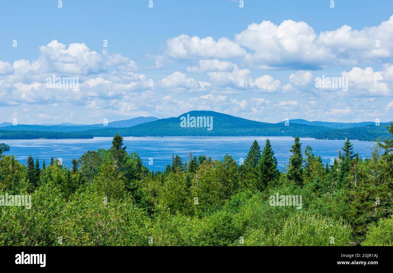 Vista panorámica del lago Rangeley, la montaña calva y las crestas distantes de las Montañas Fronterizas, más allá de un bosque de frondosas del norte de los Apalaches. Foto de stock