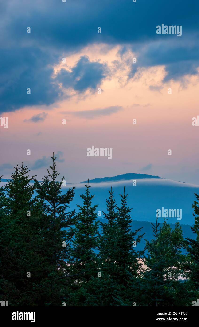 Paisaje nuboso al atardecer sobre Rangeley Lake, ME, US. Stratocumulus castellanus nubes sobre un bosque negro de abeto-bálsamo. Crestas montañosas en el horizonte. Foto de stock