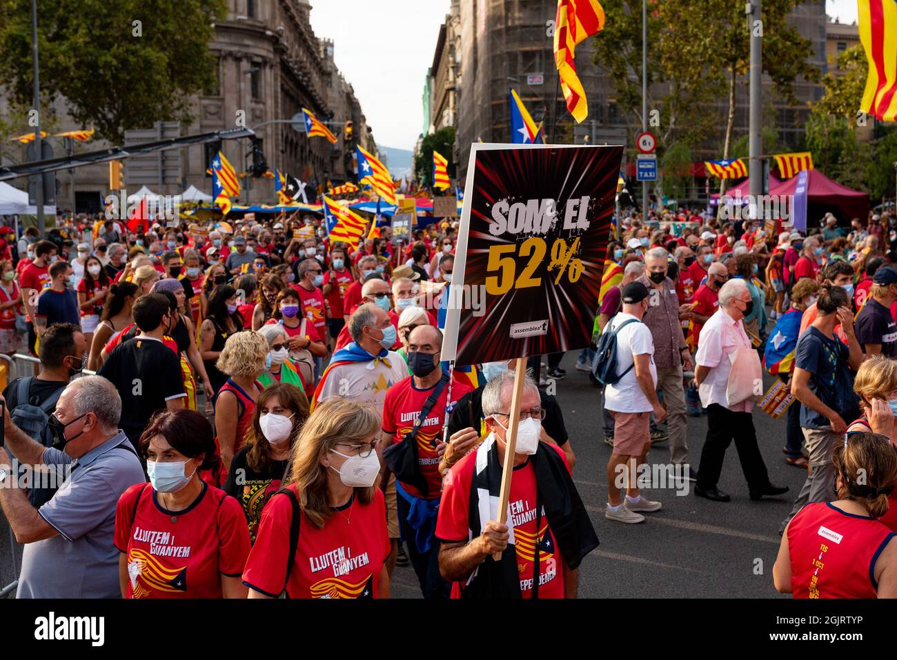 ESP. 11th de Sep de 2021. Se ve a la gente sosteniendo banderas catalanas, conocidas como Señera, y un cartel que dice 'Somos el 52%' durante las celebraciones y marchas que tienen para la fiesta catalana conocida como 'Diada' en Barcelona, España, el 11 de septiembre de 2021. Partidos separatistas catalanes y pro independencia, como el ANC, llamaron a la gente a tomar la calle en la primera gran concentración desde que comenzó la pandemia de covid, para recordar la caída de Barcelona durante la Guerra de Sucesión Española en 1714. (Foto de Davide Bonaldo/Sipa USA) Crédito: SIPA USA/Alamy Live News Foto de stock