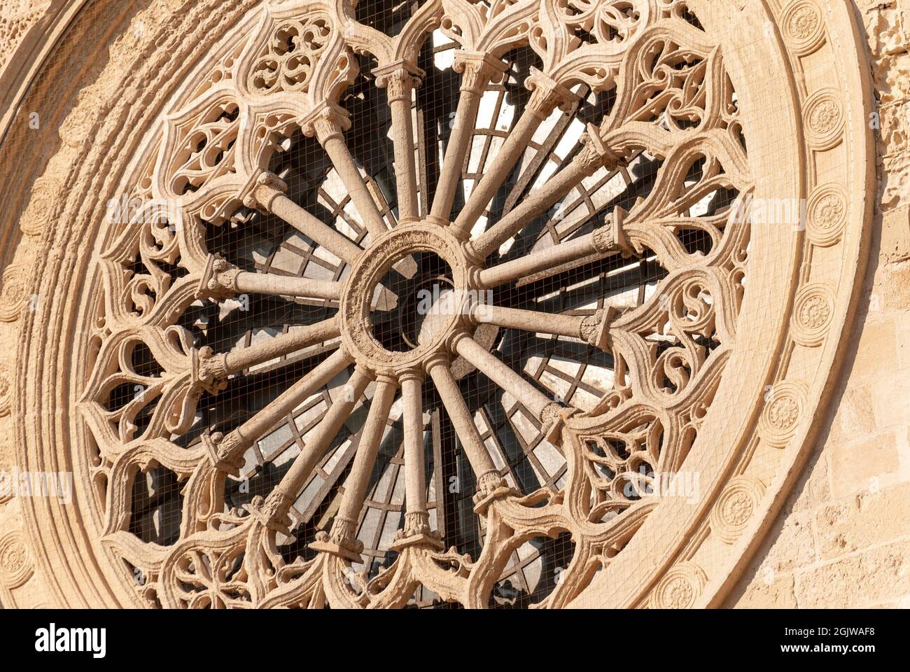 Primer plano de la rosa ventana mabé de piedra arenisca Leccese, por encima de la entrada de la Catedral de Otranto, provincia de Lecce, Salento, Puglia, Italia Foto de stock