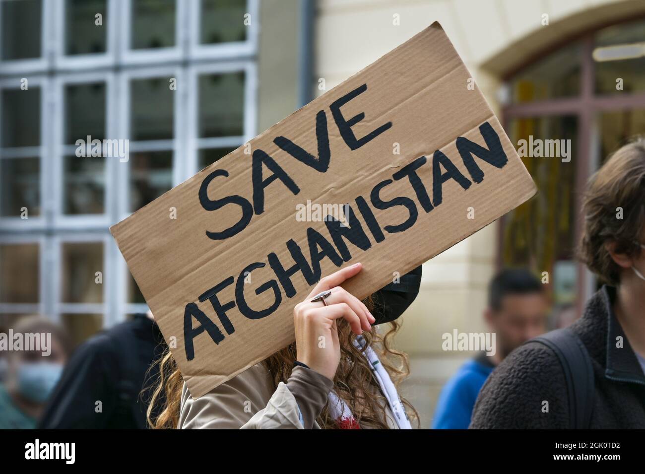 Una activista que tenía un cartel con texto Safe Afghanistan en una manifestación en Lubeck, Alemania después de la toma de posesión de los talibanes, seleccionó el foco Foto de stock