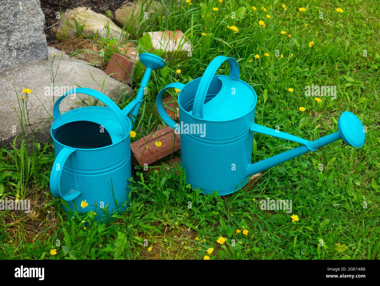 Botes de riego azules en un patio. Foto de stock