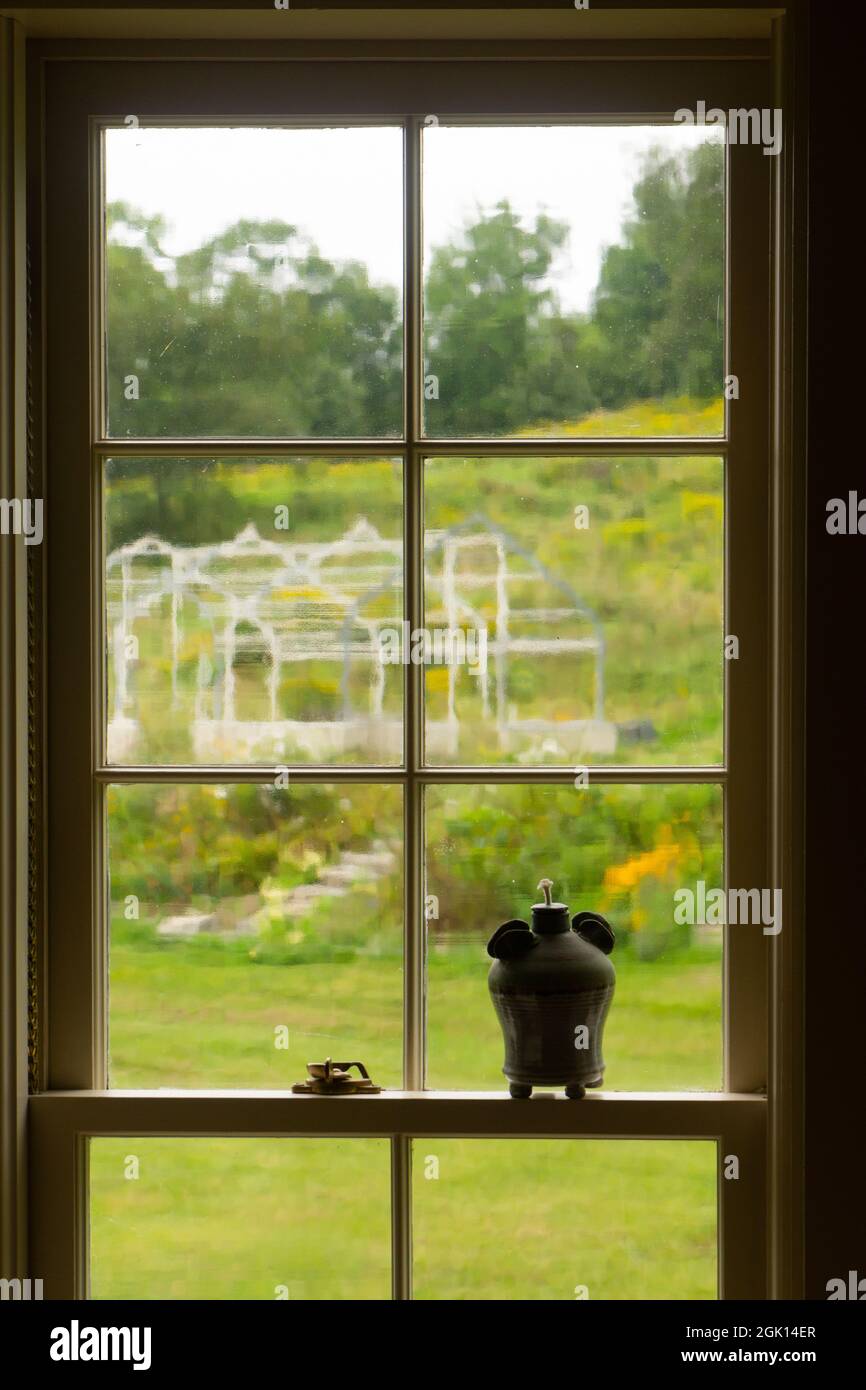 Ventana con vidrio ondulado que da a un invernadero vintage. Foto de stock