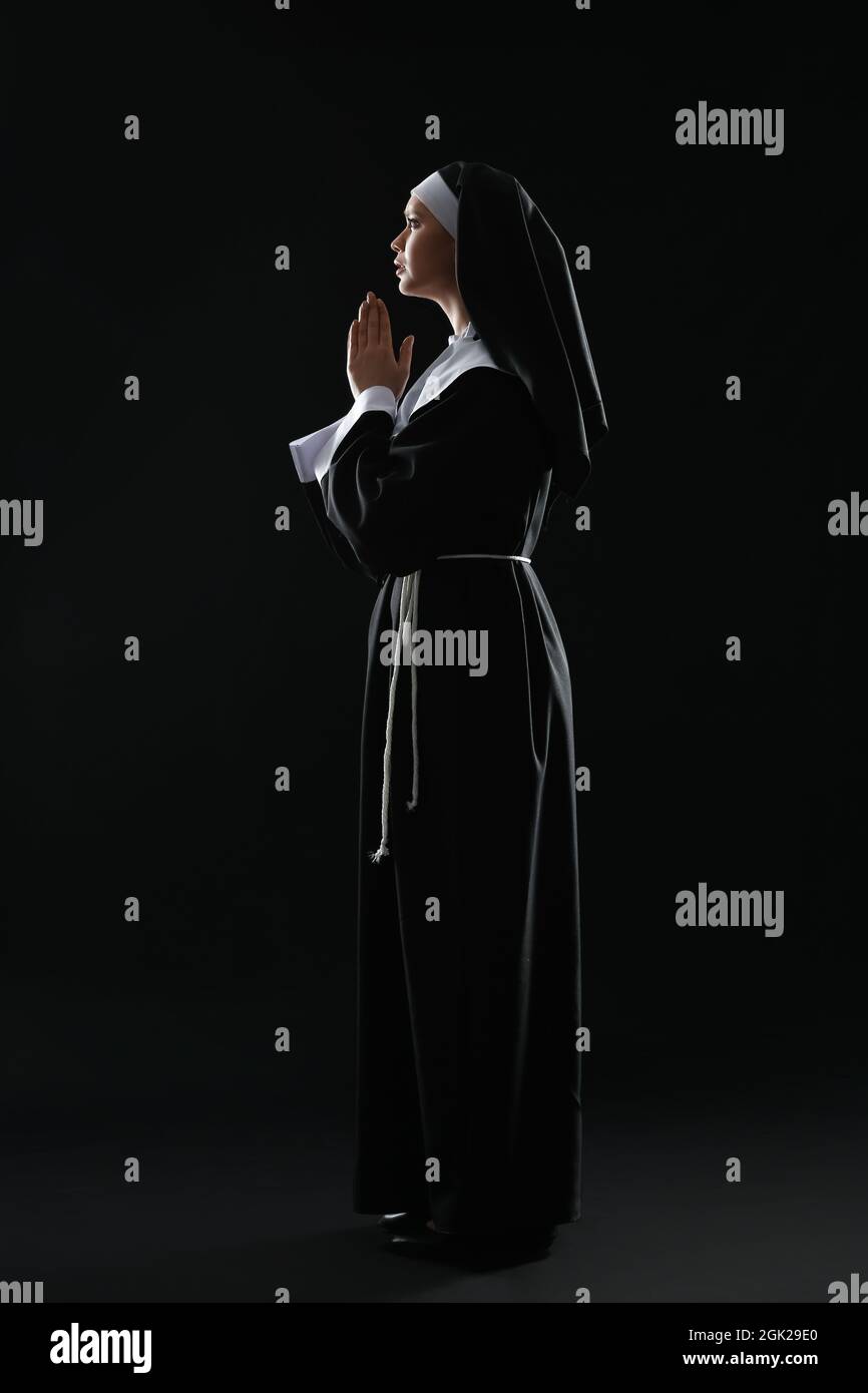 Joven rezando monja sobre fondo oscuro Fotografía de stock Alamy