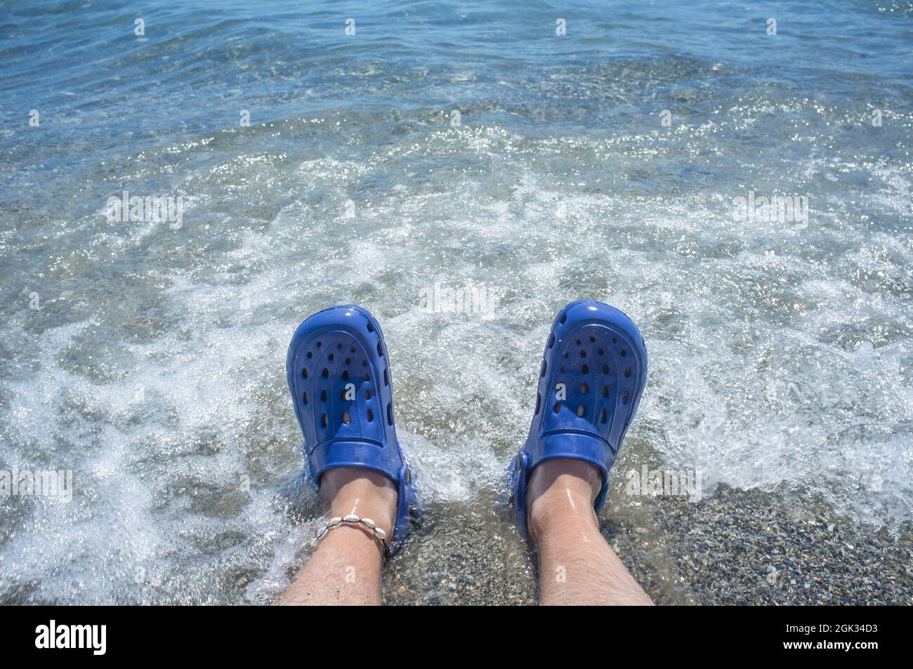 Hombre vestido con zuecos azules al lado de la playa. Enfoque selectivo  Fotografía de stock - Alamy