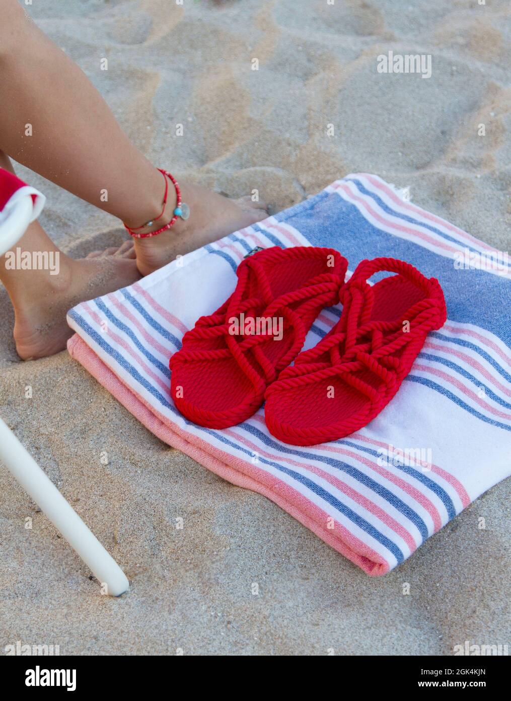 Pantuflas rojas y toalla de playa en la playa Fotografía de stock - Alamy
