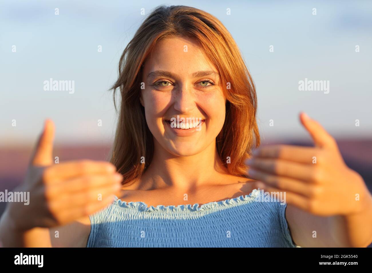 Vista frontal retrato de una mujer feliz invitándole a gesturing con las manos en el campo de lavanda Foto de stock