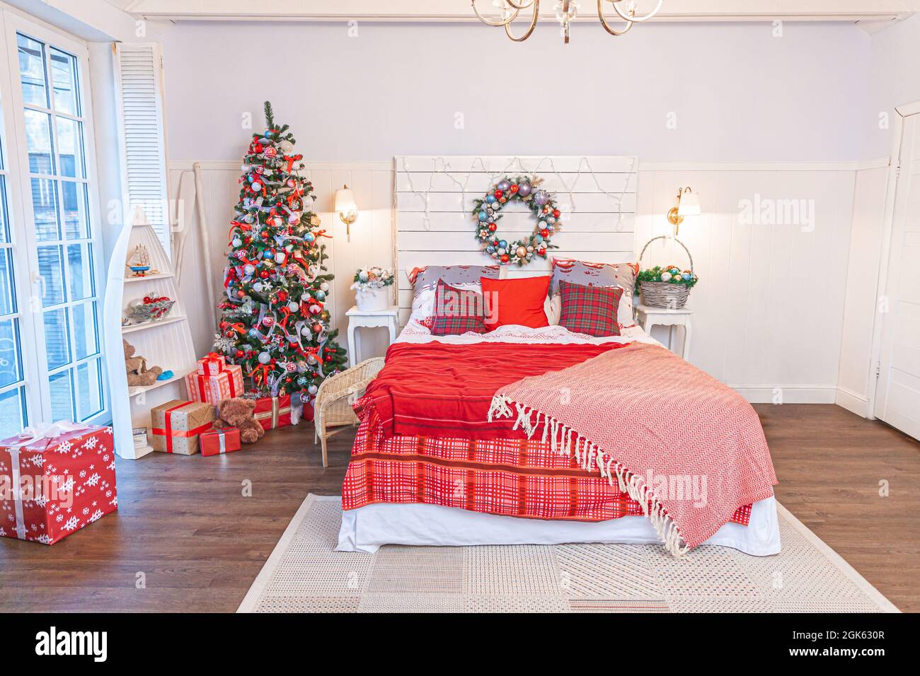 Habitación interior clásica con árbol de Navidad y decoración tradicional  de color rojo blanco. Habitación de apartamento de diseño interior moderna  y limpia, de estilo clásico y blanco Fotografía de stock -