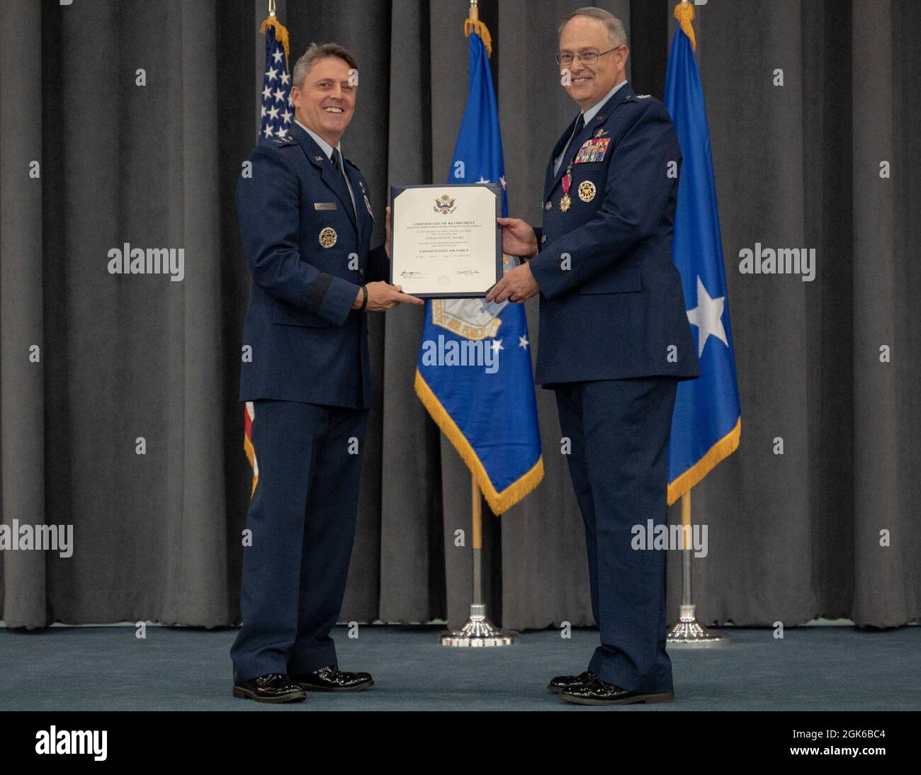 El Coronel Stookey, subdirector del Comando de Huelga Global de la Fuerza Aérea de la División de Operaciones y Comunicaciones y director de información, recibe un Certificado de Jubilación del General de División Jason Armagost, director de planes estratégicos, programas y requisitos de la AFGSC, en la Base de la Fuerza Aérea de Barksdale, Louisiana, 13 de agosto de 2021. Stookey sirvió honrosamente por más de 36 años. Foto de stock
