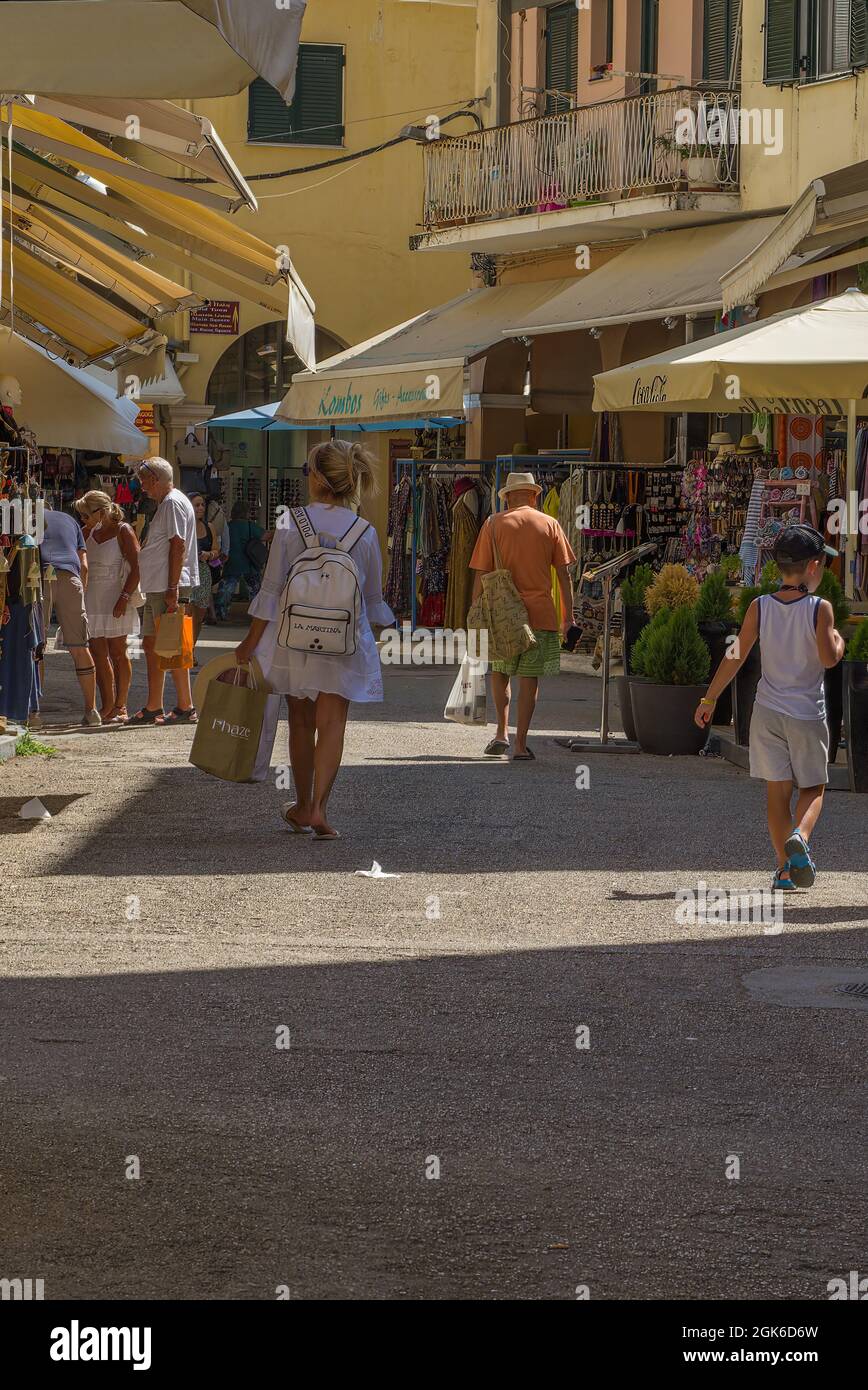 Escenas callejeras concurridas en la ciudad de Corfú con tiendas, edificios, gente y calles estrechas Foto de stock