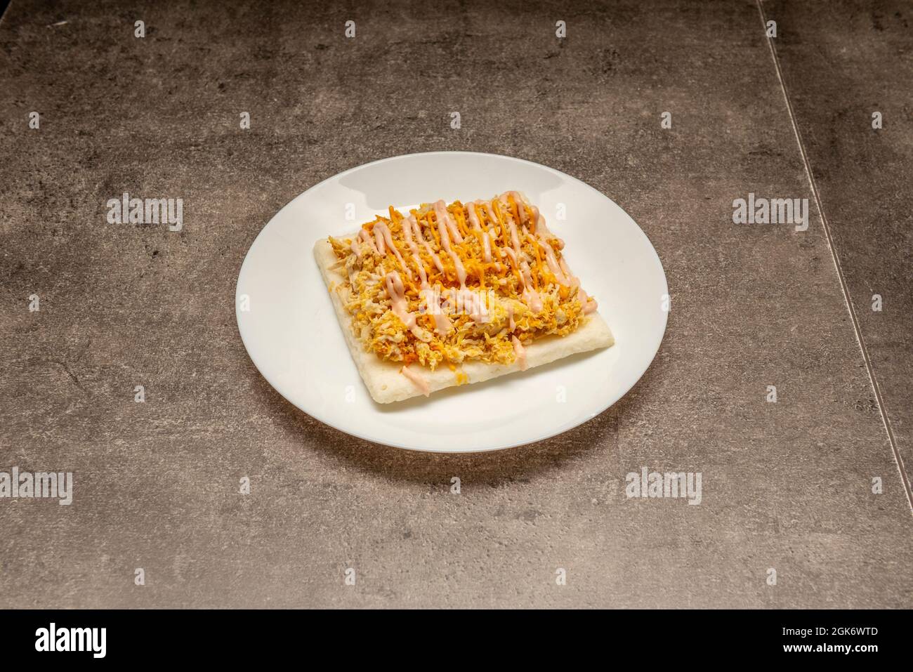 Arepa cuadrada de pollo de estilo colombiano sobre fondo gris Foto de stock