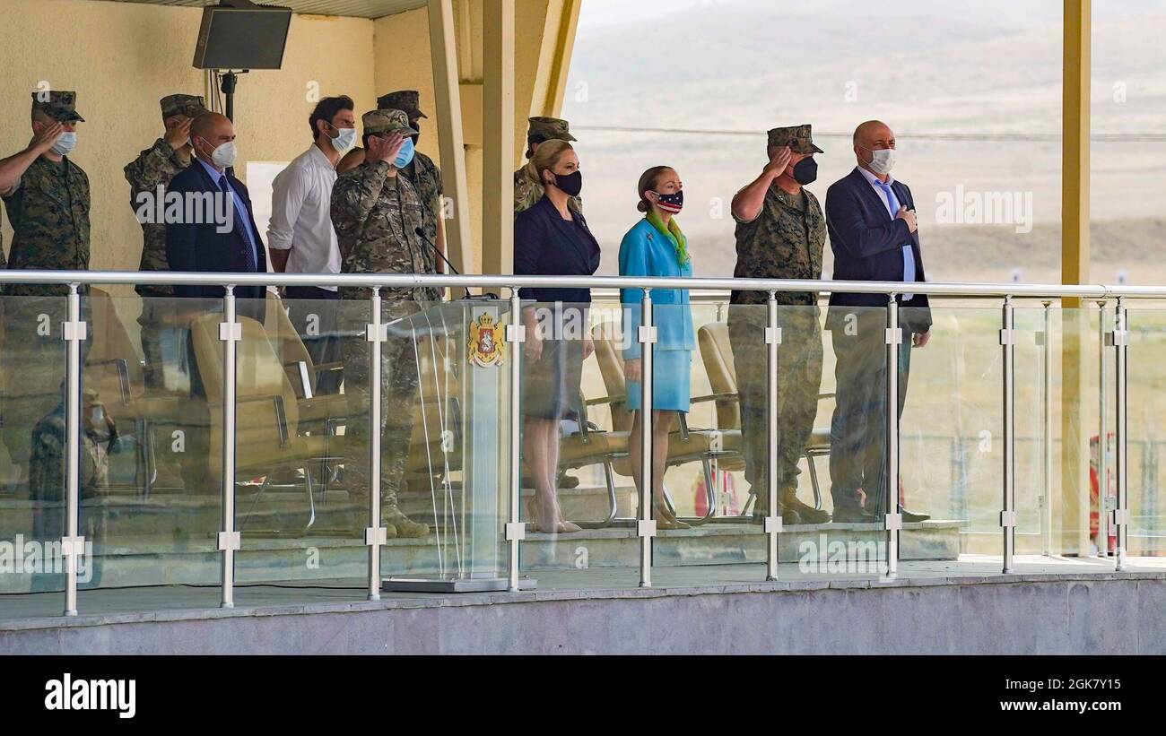 Los asistentes a la ceremonia de clausura del Programa de Despliegue de Georgia (GDP) saludan durante la interpretación de los himnos nacionales georgianos y estadounidenses en el Centro Conjunto de Capacitación y Evaluación cerca de Tbilisi, Georgia, 31 de agosto de 2021. El PIB ha llegado a su fin después de casi dos décadas de entrenamiento conjunto del Cuerpo de Infantería de Marina de los Estados Unidos y las Fuerzas de Defensa de Georgia. Foto de stock