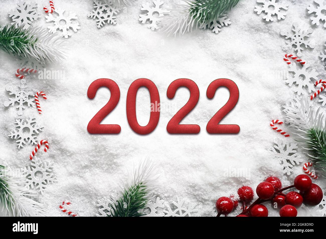 Rama de abeto con decoraciones navideñas sobre fondo blanco. 2022. Foto de stock