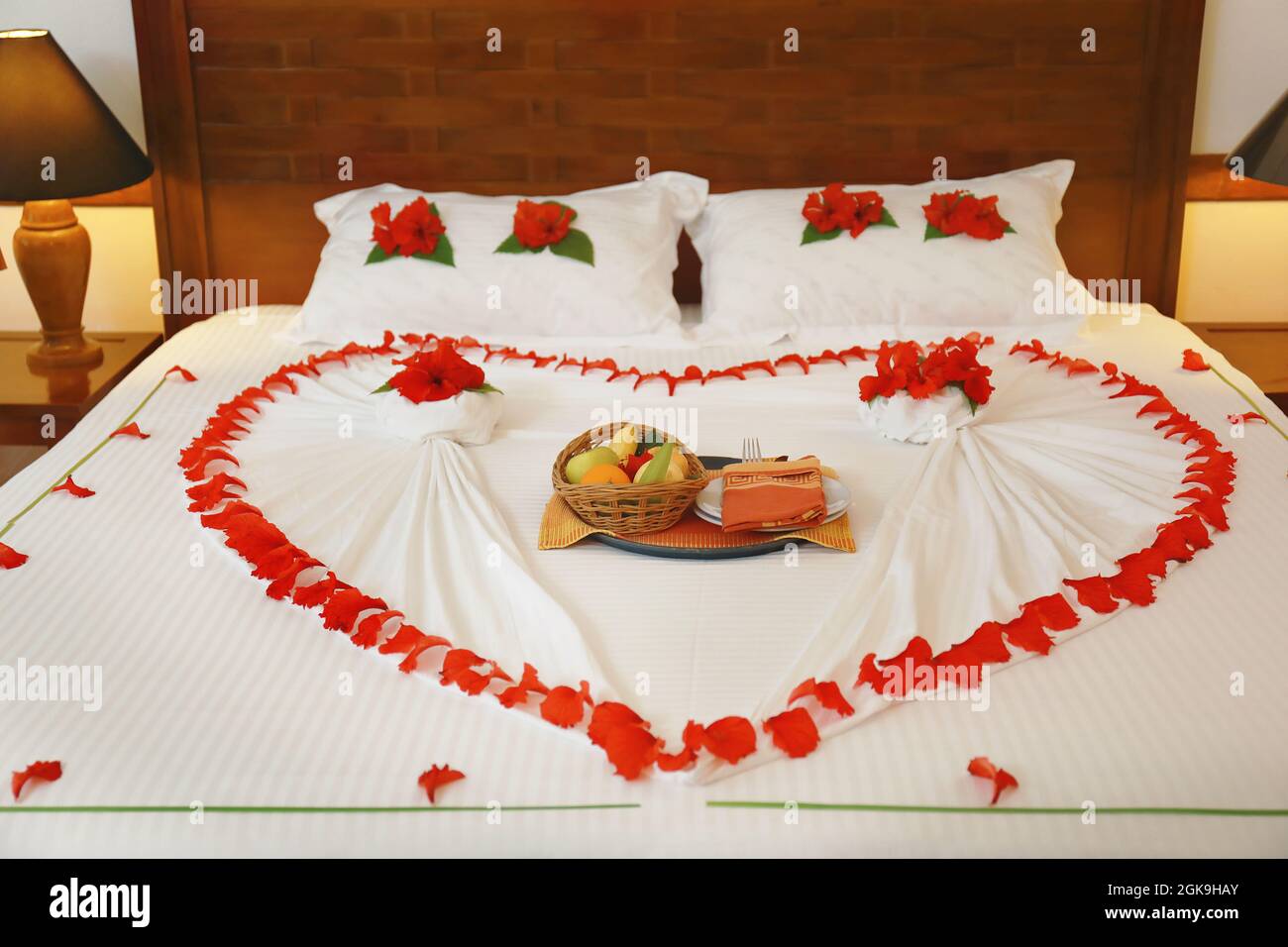 Cama con flores y frutas en la habitación del hotel preparado para la fecha  romántica Fotografía de stock - Alamy