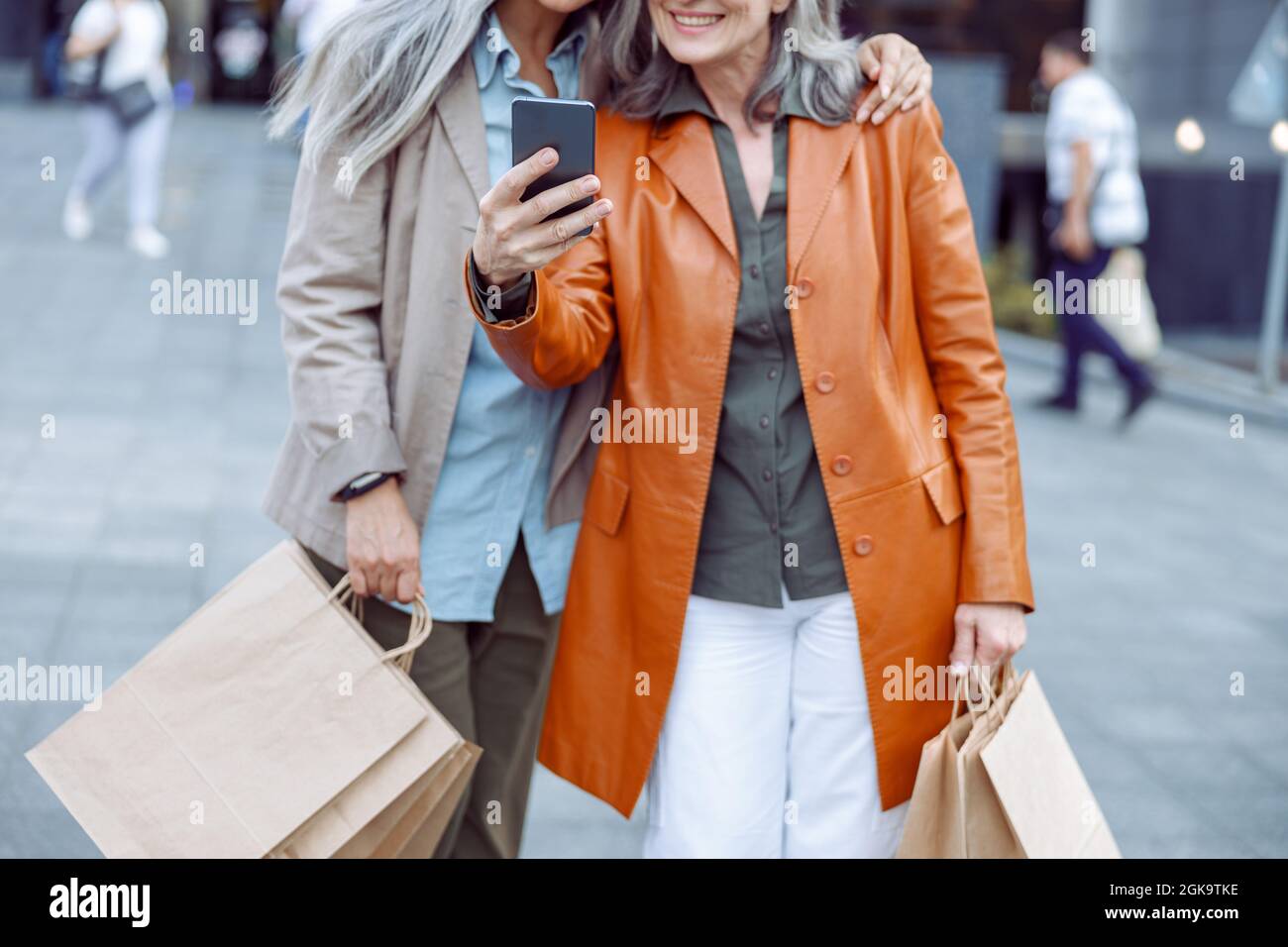 Señora mayor en chaqueta de cuero y compañero de compras tomar selfie en la  calle moderna de la ciudad Fotografía de stock - Alamy