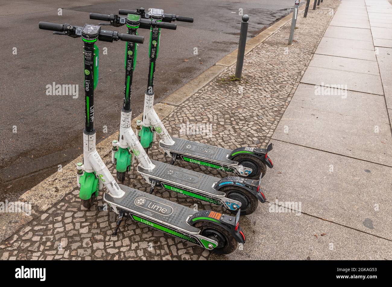 Una fila de tres de pie eléctrico escooter o e-scooter de LA empresa DE CAL en la acera de Berlín Foto de stock