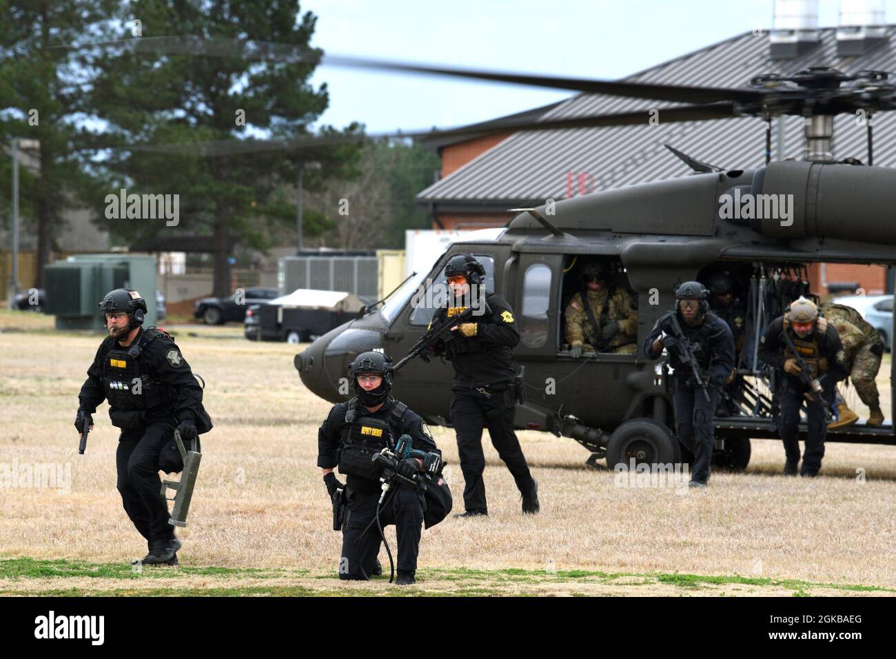 169th Defensores de las Fuerzas de Seguridad del ala de combate se unen con oficiales locales de la policía del Equipo de Respuesta Especial (SRT) del Departamento del Sheriff del Condado de Richland para conducir entrenamiento de tiradores activos entre agencias en la Base Conjunta de la Guardia Nacional McEntire, Carolina del Sur, 2 de marzo de 2021. LOS helicópteros utilitarios de elevación media de Black Hawk UH-60 de la compañía A del batallón de aviación 1-111st de Carolina del Sur, transportaron el SRT para unirse a los defensores de la base de la Fuerza Aérea de EE.UU. Para participar en amenazas de ejercicios de disparos activos, demostrando capacidades de respuesta rápida. Foto de stock