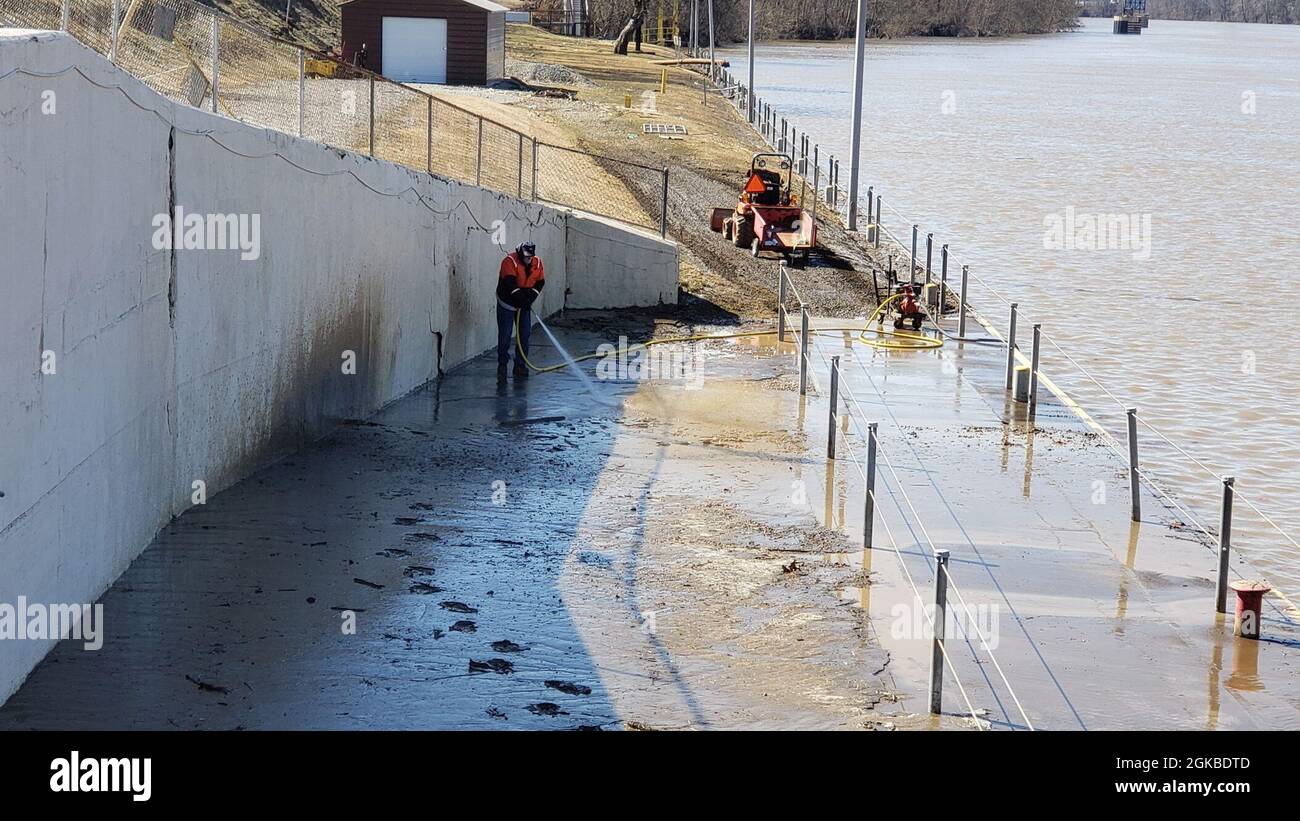 Incluso después de que las aguas de las inundaciones han retrocedido, los miembros de la tripulación tienen que rociar barro y limpiar los escombros en las esclusas y las presas 3 en el río Monongahela en Elizabeth, Pensilvania, el 2 de marzo de 2021. La limpieza puede tomar a menudo dos semanas después de una inundación. El agua alta de la nieve se derrite y la lluvia extendida afectó al Cuerpo de Ingenieros del Ejército de los Estados Unidos en el Distrito de Pittsburgh en el Río Monongahela a principios de marzo. Elizabeth Locks and Dams (L/D 3) fue sacada de servicio cuando el agua entró en la maquinaria operativa y coronó las paredes de la cerradura. El tiempo promedio de parada de la operación con alto nivel de agua fue de 30 horas. El personal de la cerradura limpió el barro Foto de stock