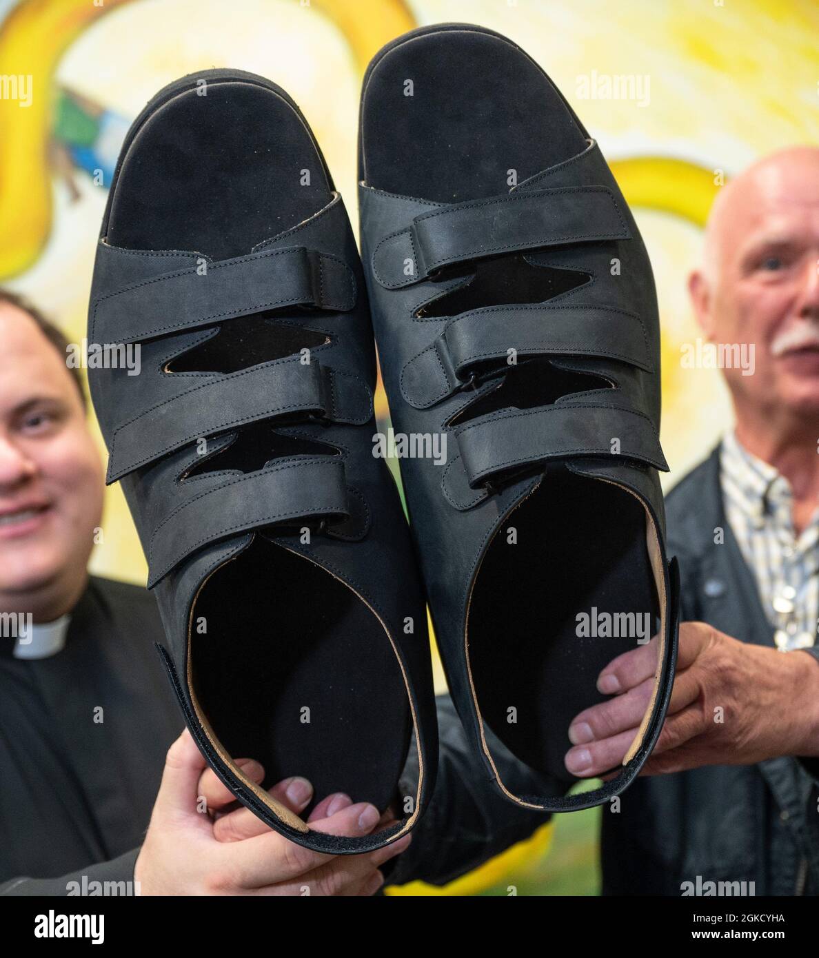 14 de septiembre de 2021, Renania del Norte-Westfalia, Essen: El Shoemaker  Georg Wessels (r) muestra las nuevas sandalias para los pies más grandes  del mundo con el Padre Alejandro Keri de Caracas,