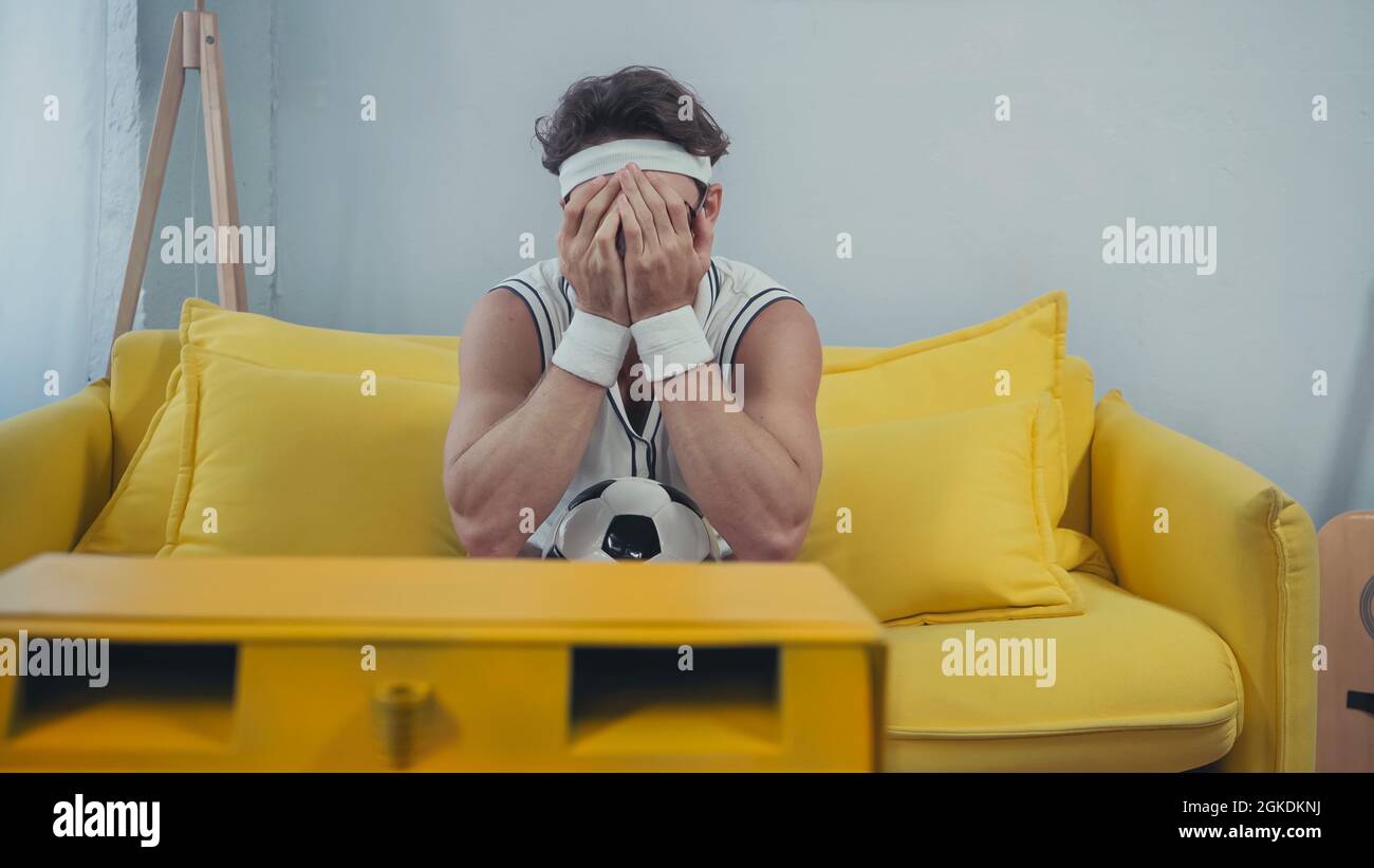 disgustó a los fanáticos del fútbol en la cara de la ropa deportiva  mientras veían la televisión en el sofá Fotografía de stock - Alamy