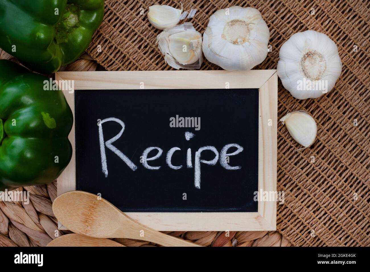 La palabra receta escrita en pizarra negra con mesa rústica Foto de stock