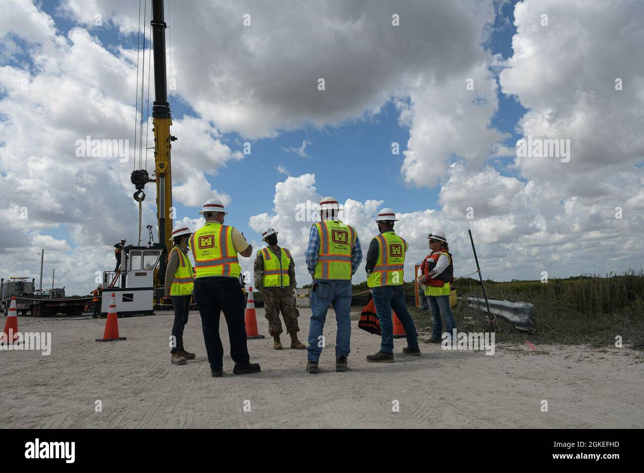 Cuerpo de Ingenieros del Ejército de los Estados Unidos Distritos de Jacksonville, Comandante, Coronel Andrew Kelly visita con la Oficina Residente de Restauración de Miami. El equipo observa los inicios de la ejecución programática del contrato 1 del Proyecto de Planificación de los Everglades Centrales. Una grúa en el proyecto de planificación de los Everglades centrales contrato 1 levanta la torre de un remolcador que transportará barcazas hasta el canal L-67. Las barcazas eliminan los despojos a través del dique L-67A. El Proyecto de Planificación de los Everglades Centrales identificará y planificará proyectos en tierras que ya son de propiedad pública para permitir que más agua se dirija al sur Foto de stock