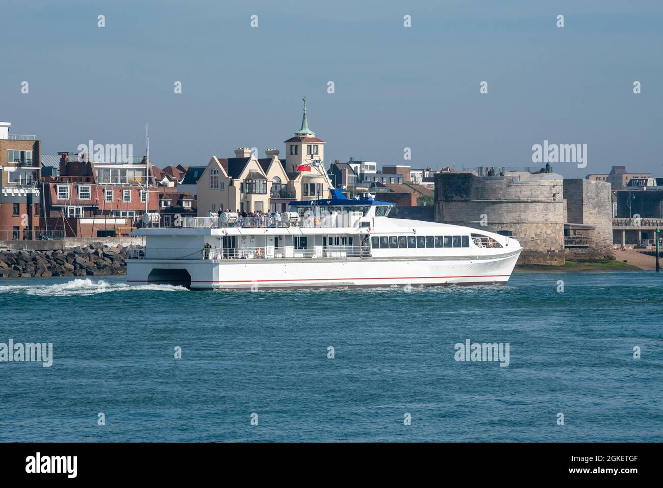 Portsmouth, Inglaterra, Reino Unido. 2021. Un ferry en catamarán para pasajeros que sale del puerto de Portsmouth pasando por la fortificación de la Torre Redonda. Foto de stock