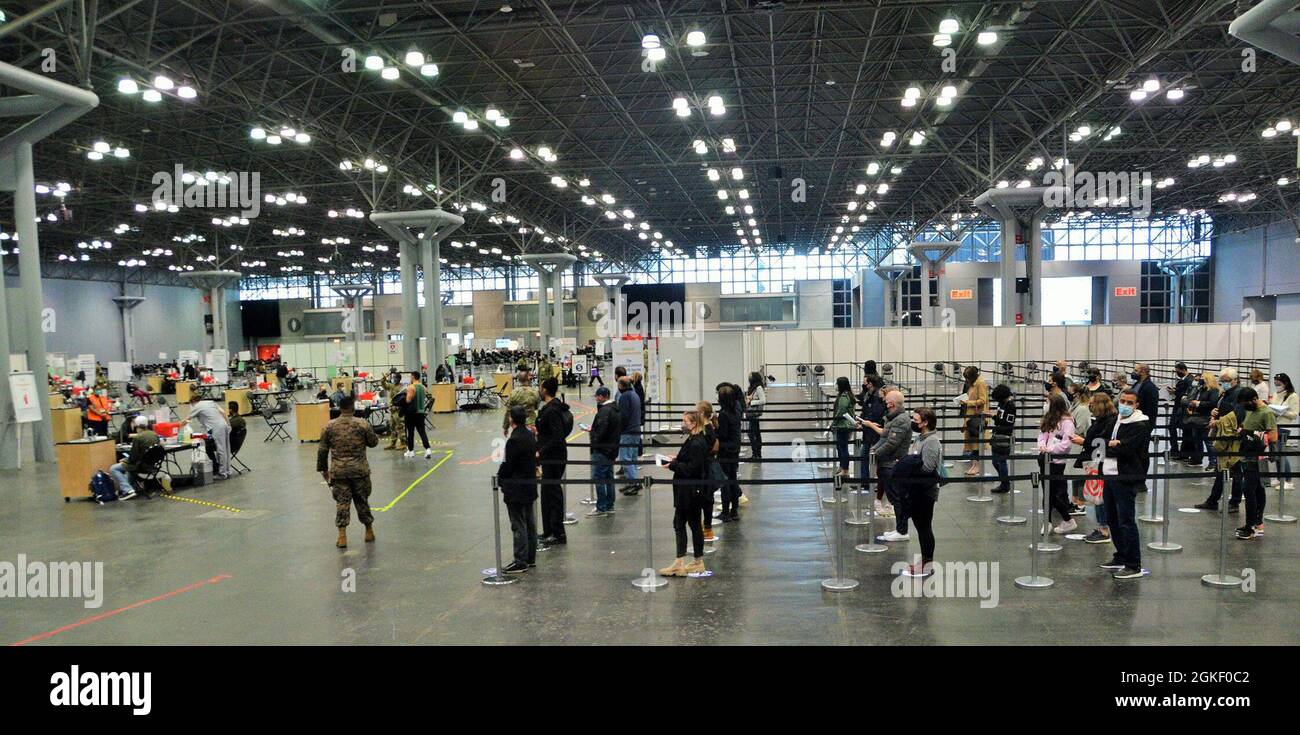 Los miembros de la Guardia Nacional de Nueva York dirigen a los receptores de la vacuna COVID-19 a su centro médico en el Sitio de Vacunación Masiva del Centro de Convenciones Jacob K. Javits en Manhattan, Nueva York, 6 de abril de 2021. El centro de convenciones sirve como un sitio de vacunación masiva con más de 600 miembros del personal de la Guardia Nacional ayudando con la administración, logística y operaciones de vacunas en apoyo del Departamento de Salud del Estado de NY. Foto de stock