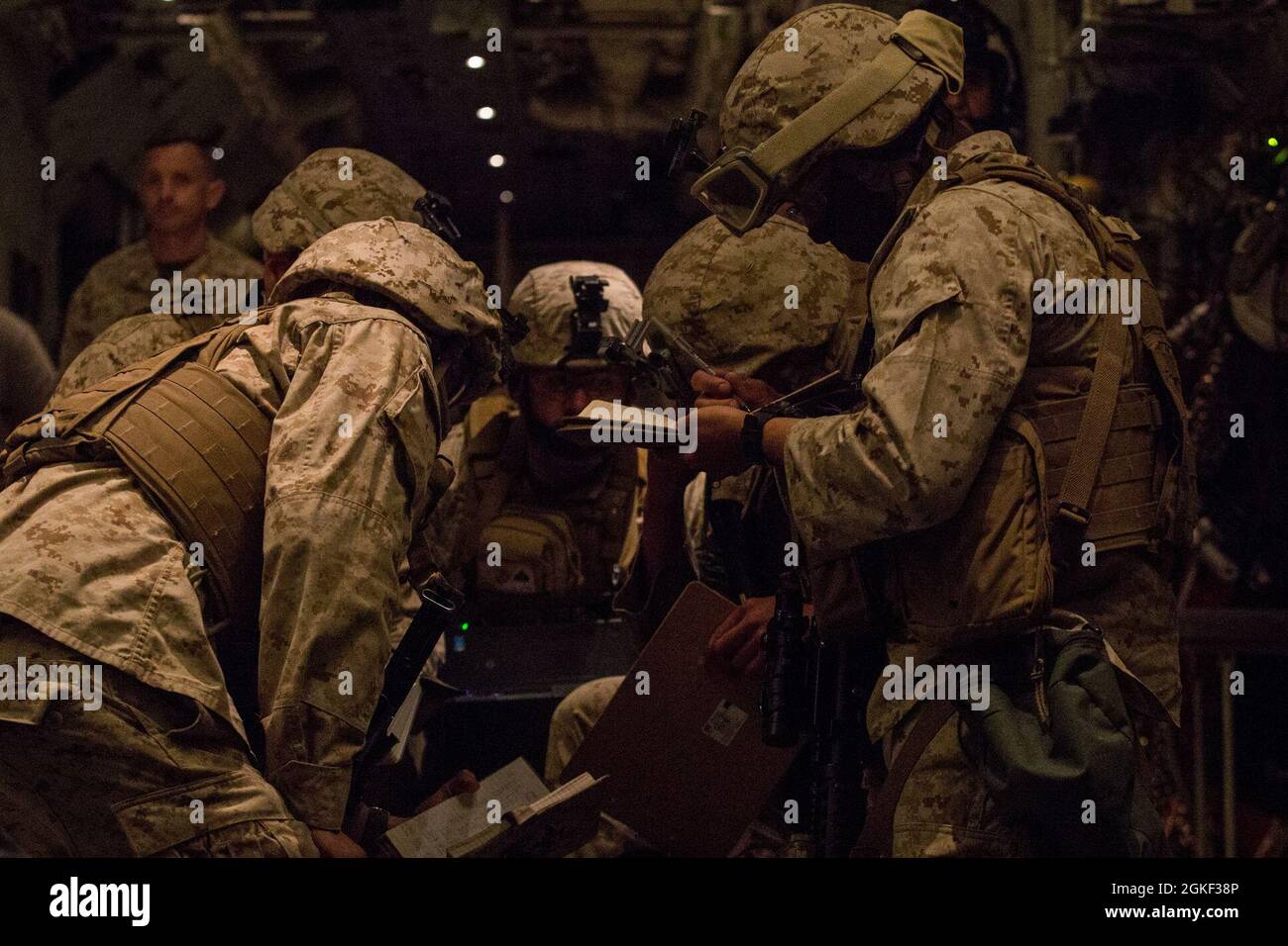 Marines con Fox Battery, Batallón 2nd, Regimiento Marino 14th, División Marina 4th, coordinan los detalles de un ejercicio de inserción rápida utilizando un sistema nocional de cohetes de artillería de alta movilidad M142 (HIMARS), durante un ejercicio de inserción rápida en apoyo del curso de Instructor de Armas y Tácticas (WTI) 2-21, en la Isla de San Clemente, California, 5 de abril de 2021. El curso WTI es un evento de capacitación de siete semanas organizado por el Escuadrón de Armas y Tácticas de Aviación Marina (MAWTS-1), que proporciona entrenamiento táctico avanzado estandarizado y certificación de las calificaciones de instructores de unidad para apoyar a Marine avi Foto de stock