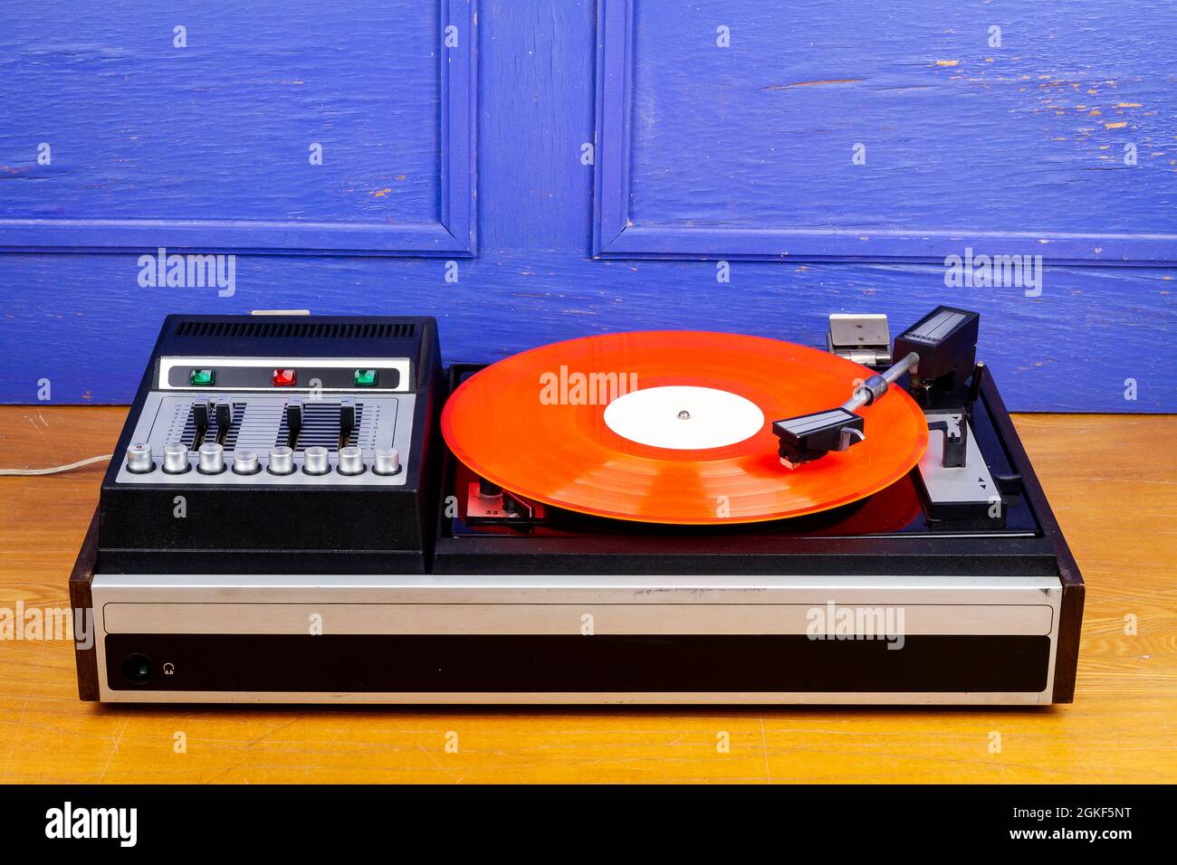 Vintage tocadiscos vinilo con vinilo rojo sobre mesa por pared azul  Fotografía de stock - Alamy