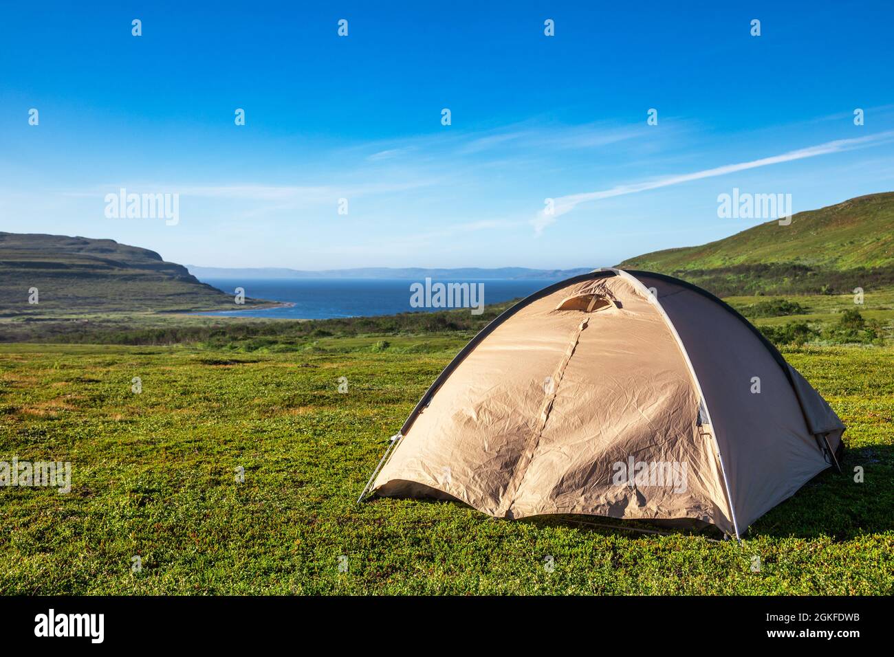 Tienda de camping en camping escénico en la costa del Océano Ártico con cordillera en el fondo - concepto de camping salvaje Foto de stock