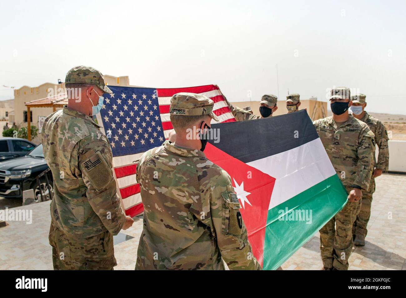 Las Fuerzas Armadas de Jordania, Mando del Sur, Comandante del Grupo de Guardia de Fronteras de 3rd, Coronel Ra'ad Al Aamayra, Y Task Force Spartan Division Tactical-Jordan Oficial a cargo, Coronel Christopher Fletcher, intercambiaron banderas en un gesto simbólico de amistad y asociación tras la exitosa finalización del ejercicio de fuego vivo Desert Warrior 21, 8 de abril de 2021. El ejercicio fue visto por oficiales generales de la JAF y altos líderes de la Central del Ejército de los Estados Unidos y del TF Spartan. Los momentos de gratitud expresa ayudan a consolidar la relación duradera entre las dos fuerzas. Foto de stock