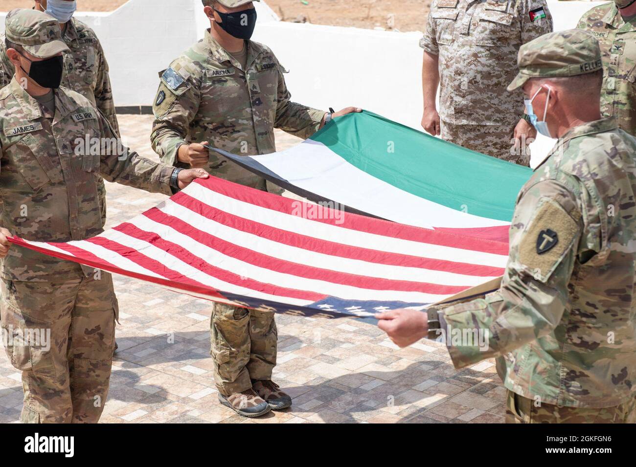 Las Fuerzas Armadas de Jordania, Mando del Sur, Comandante del Grupo de Guardia de Fronteras de 3rd, Coronel Ra'ad Al Aamayra, Y Task Force Spartan Division Tactical-Jordan Oficial a cargo, Coronel Christopher Fletcher, intercambiaron banderas en un gesto simbólico de amistad y asociación tras la exitosa finalización del ejercicio de fuego vivo Desert Warrior 21, 8 de abril de 2021. El ejercicio fue visto por oficiales generales de la JAF y altos líderes de la Central del Ejército de los Estados Unidos y del TF Spartan. Los momentos de gratitud expresa ayudan a consolidar la relación duradera entre las dos fuerzas. Foto de stock