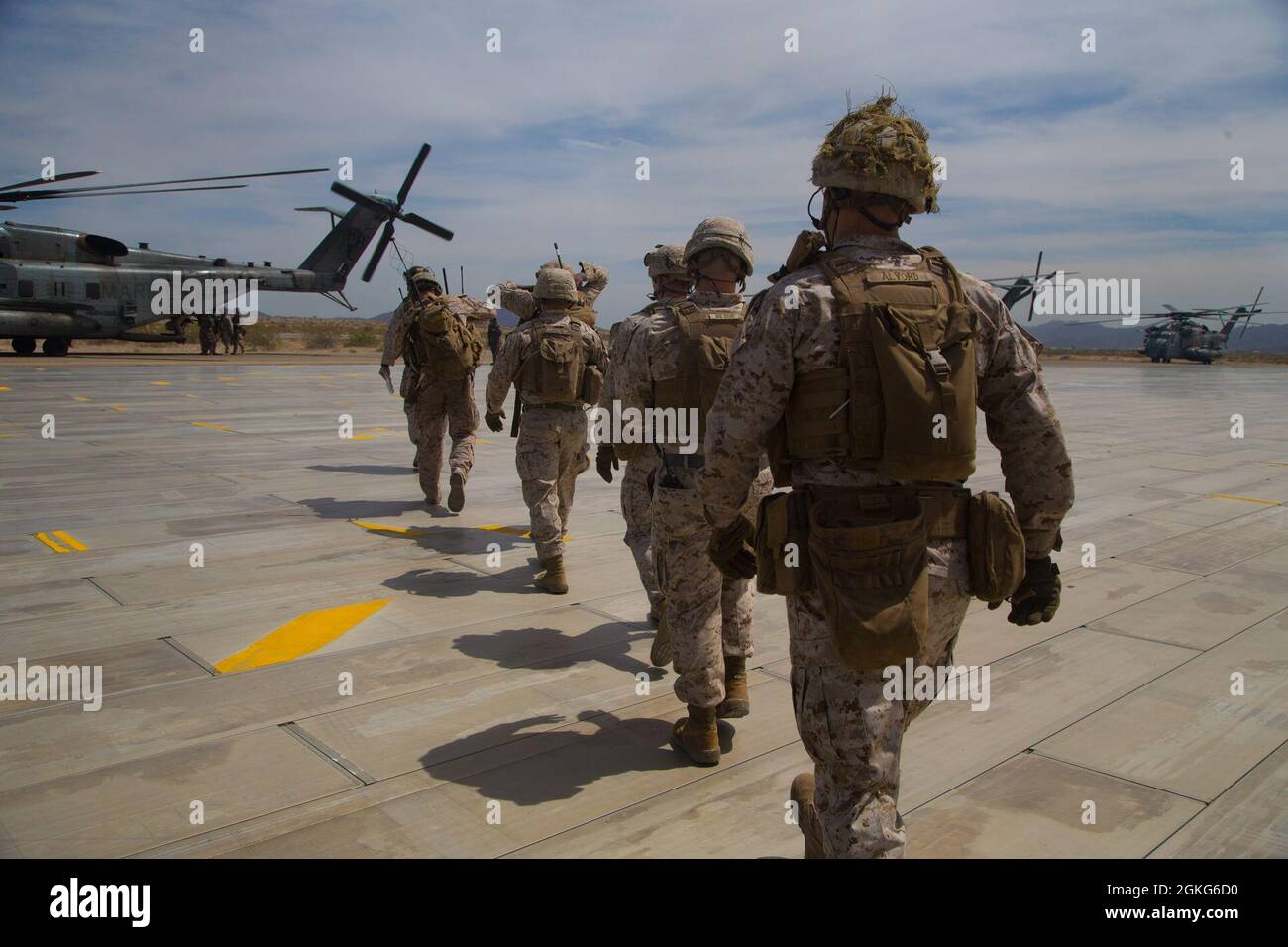 Marines de los Estados Unidos asignados al Escuadrón Uno de Armas y Tácticas de Aviación Marina (MAWTS-1), caminan a través de la pista para abordar un Super Stallion CH-53E, para ser transportados a un apoyo por la evolución del fuego en apoyo del curso de Instructor de Armas y Tácticas (WTI) 2-21, en el área de entrenamiento del Sitio 50, cerca de Wilton, Arizona, 15 de abril de 2021. El curso WTI es un evento de capacitación de siete semanas organizado por MAWTS-1, que proporciona capacitación táctica avanzada estandarizada y certificación de las calificaciones de instructores de unidad para apoyar la preparación y capacitación de la aviación marina, y ayuda en el desarrollo y empleo de armas y tac de aviación Foto de stock