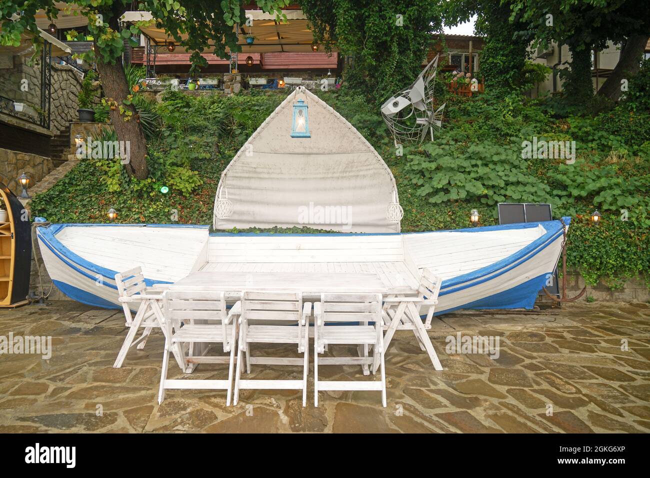 Mesa con sillas y banco en forma de barco en el patio del hotel Fotografía  de stock - Alamy
